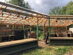 Wooden structure with open sides and corrugated plastic roof