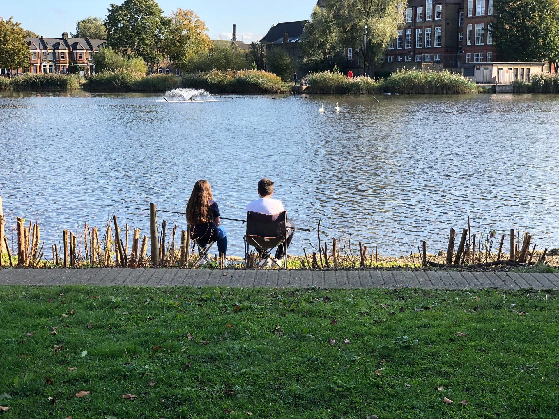 Two people fishing by a lake